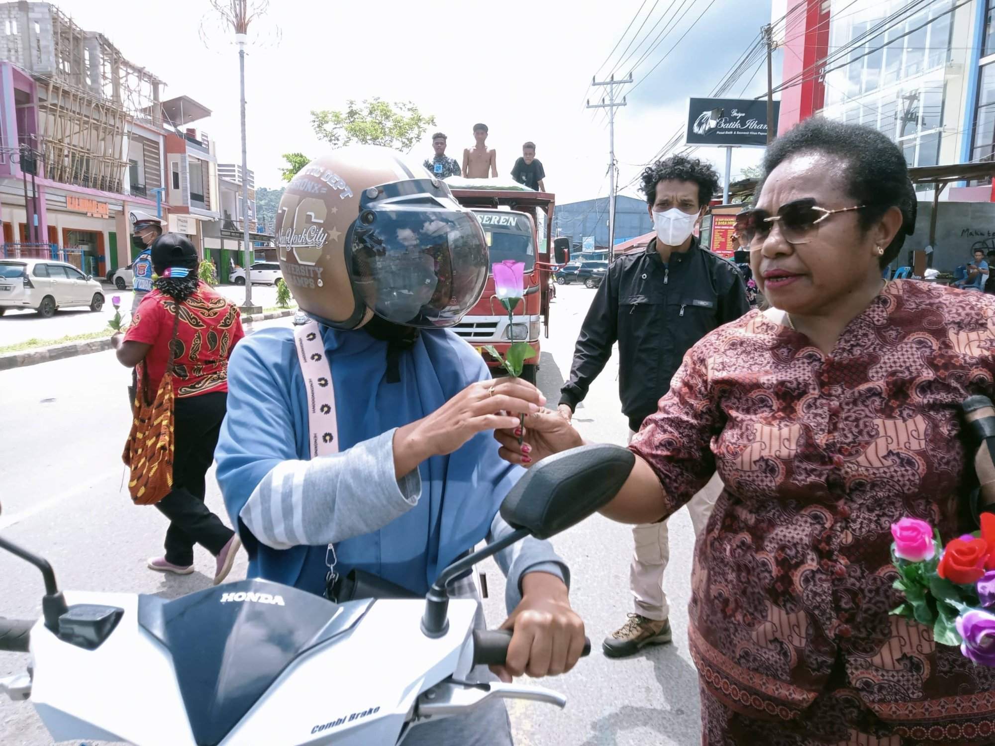 Sarce Meidodga Ketua Ikatan perhimpunan perempuan Arfak Papua Barat saat memberi setangkai bunga kepada pengendara di Jalan Trikora Wosi-Adlu